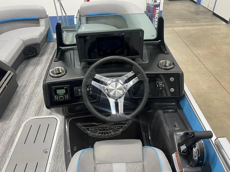 Slide: The Image of 2025 Bennington 22M FASTBACK boat dashboard with steering wheel and controls. - 2