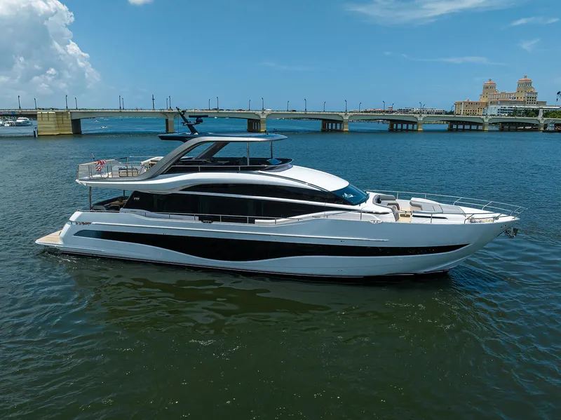 Slide: The Image of 2025 Princess Y85 Motor Yacht cruising on a sunny day near a bridge. - 1