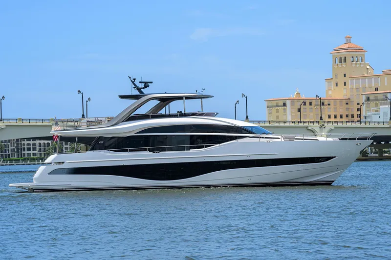 Slide: The Image of 2025 Princess Y85 Motor Yacht cruising on a sunny day near a coastal cityscape. - 11