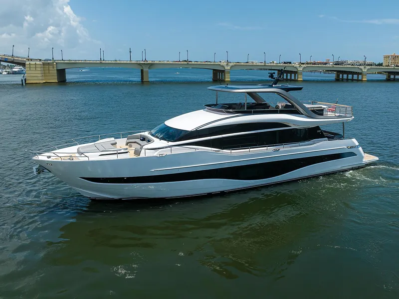 Slide: The Image of 2025 Princess Y85 Motor Yacht cruising on a sunny day near a bridge. - 2