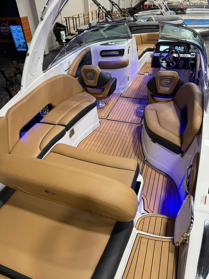 Slide: The Image of 2025 Crownline 280 SS boat interior with tan leather seating and blue LED lighting. - 2