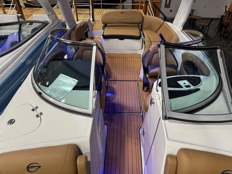 Slide: The Image of 2025 Crownline 280 SS boat interior with tan seating and wood flooring. - 4
