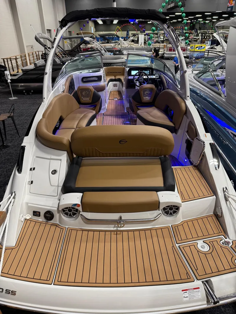 Slide: The Image of 2025 Crownline 280 SS boat with luxurious seating and modern design at a showroom. - 5