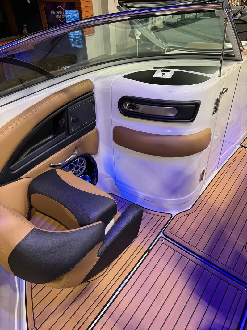Slide: The Image of 2025 Crownline 280 SS boat interior with tan and black seating, wood flooring. - 7