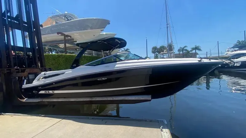 Slide: The Image of 2015 Sea Ray 250 SLX boat docked at marina under clear blue sky. - 30