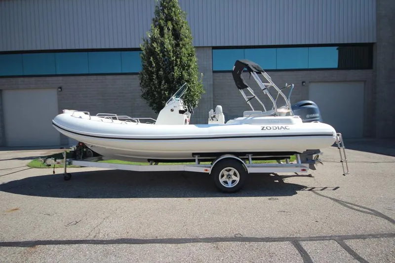 The Image of 2025 Zodiac Medline 6.8 NEO boat on trailer, parked outside industrial building. - 0