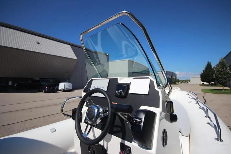 Slide: The Image of 2025 Zodiac Medline 6.8 NEO boat with canopy, parked outside industrial building. - 19