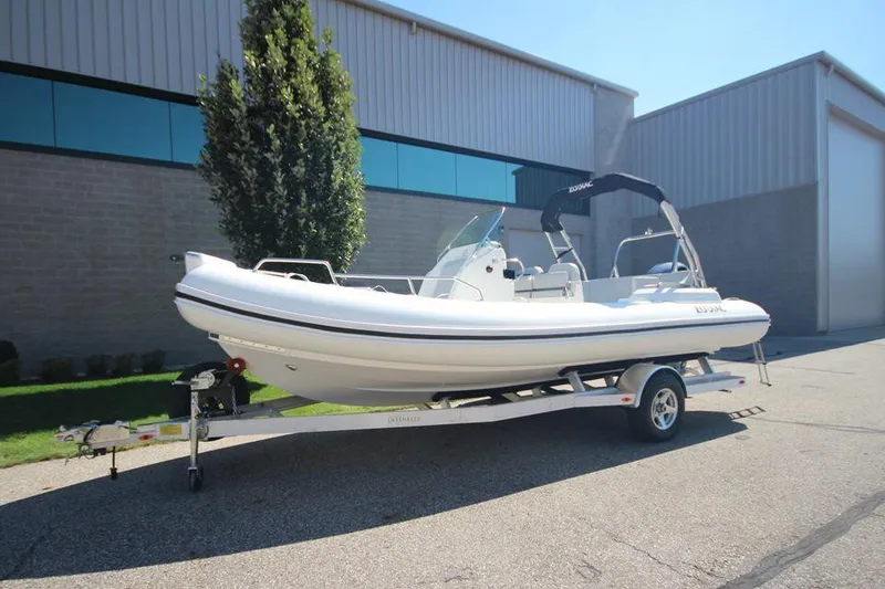 Slide: The Image of 2025 Zodiac Medline 6.8 NEO boat on trailer outside industrial building. - 1