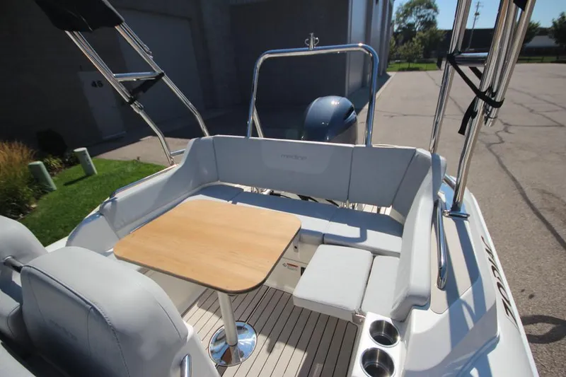 Slide: The Image of 2025 Zodiac Medline 6.8 NEO boat steering console with controls, parked outdoors. - 11