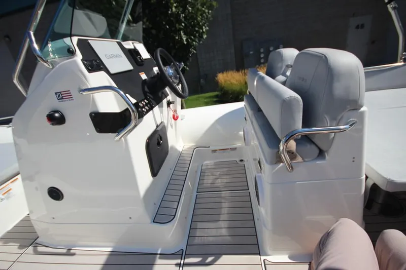 Slide: The Image of 2025 Zodiac Medline 6.8 NEO boat, white deck, parked outdoors near storage units. - 17