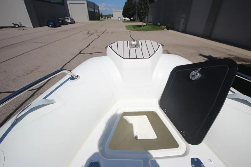 Slide: The Image of 2025 Zodiac Medline 6.8 NEO boat storage compartment open, showcasing interior space. - 28