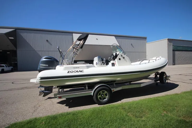 Slide: The Image of 2025 Zodiac Medline 6.8 NEO boat with 200hp engine, parked outdoors. - 4