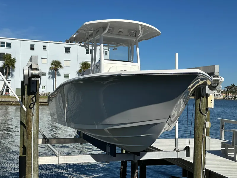 Slide: The Image of 2023 Sea Pro 239 Deep V CC boat on lift by waterfront building. - 0