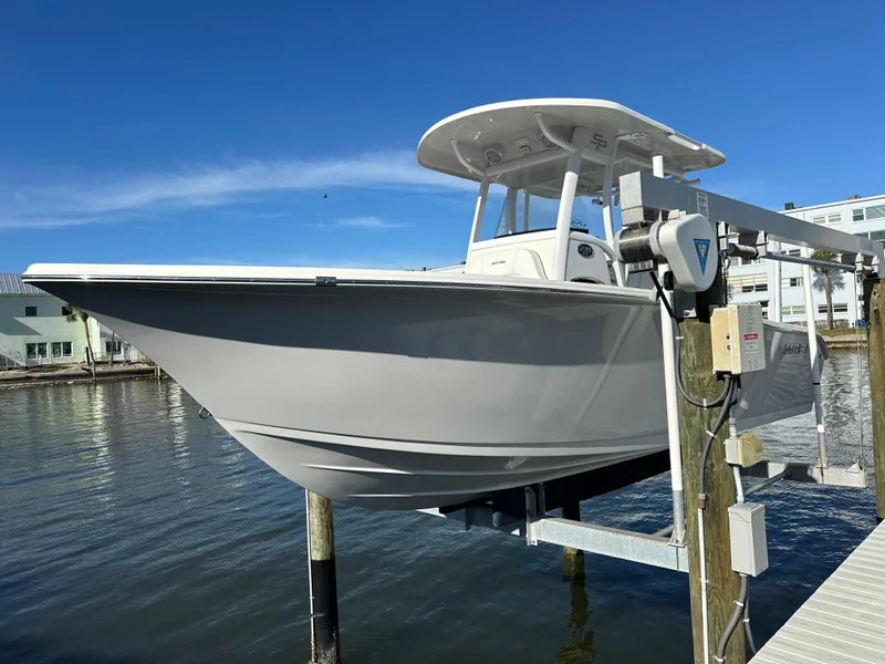 Slide: The Image of 2023 Sea Pro 239 Deep V CC boat on lift, docked by waterfront homes. - 1