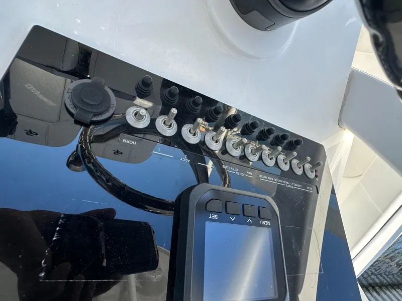 Slide: The Image of Control panel of 2023 Sea Pro 239 Deep V CC boat with switches and display. - 17