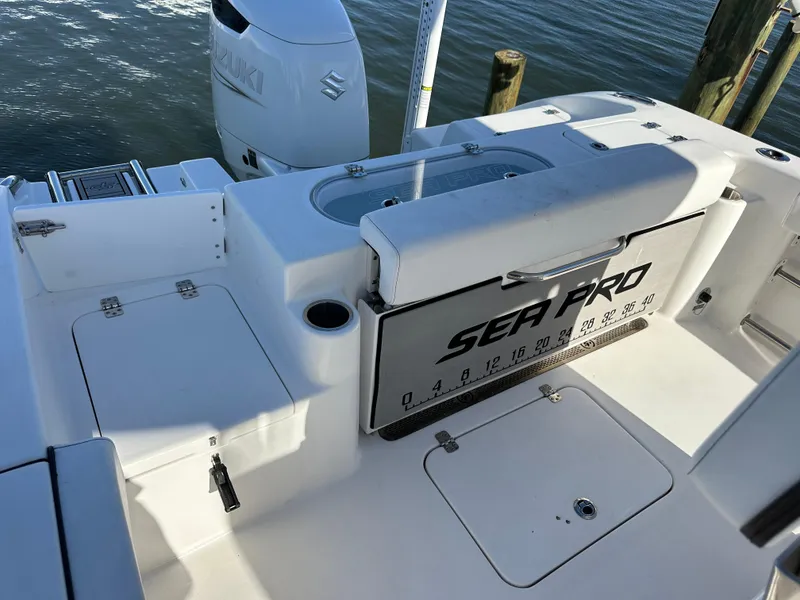 Slide: The Image of 2023 Sea Pro 239 Deep V CC boat interior with Suzuki engine, docked by the water. - 21