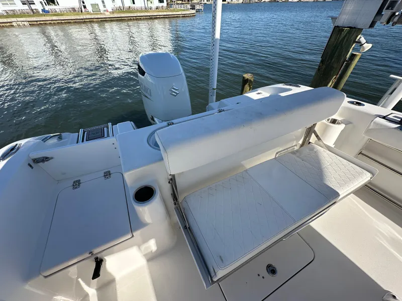 Slide: The Image of 2023 Sea Pro 239 Deep V CC boat interior with seating and motor, docked by the water. - 25