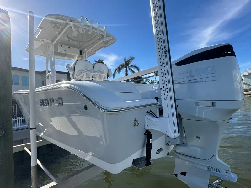 Slide: The Image of 2023 Sea Pro 239 Deep V CC boat with Suzuki engine, docked by palm trees. - 27
