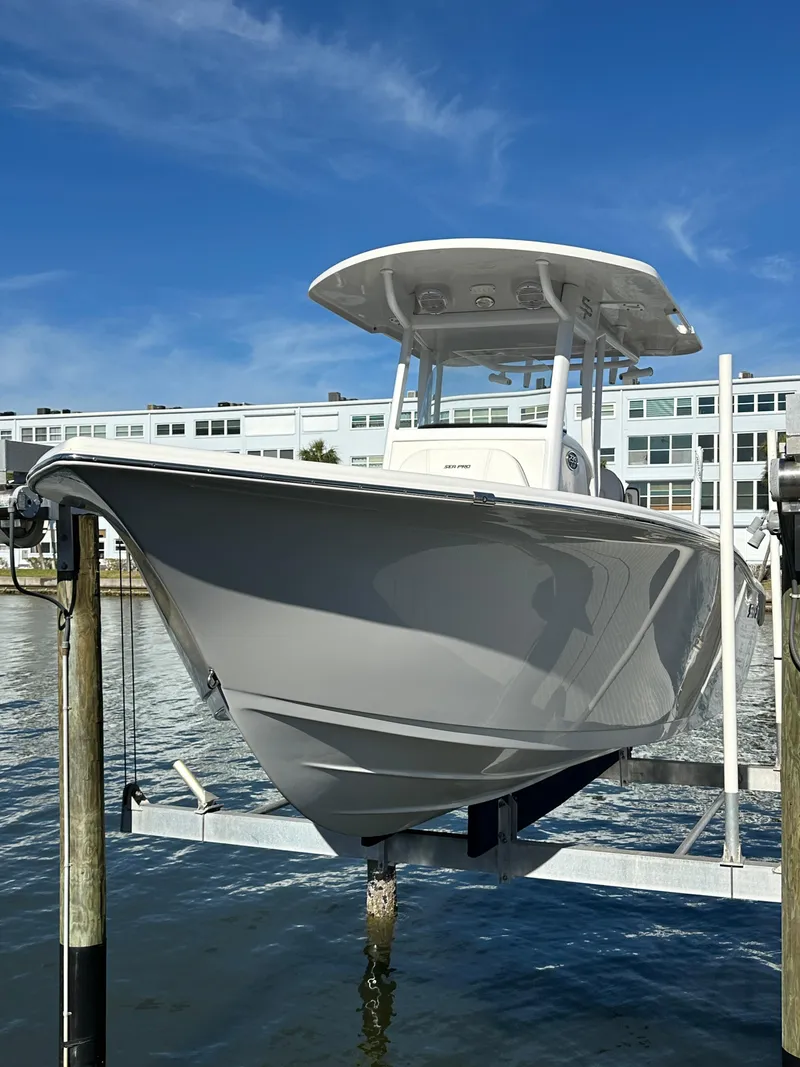 Slide: The Image of 2023 Sea Pro 239 Deep V CC boat on lift, waterfront view. - 32