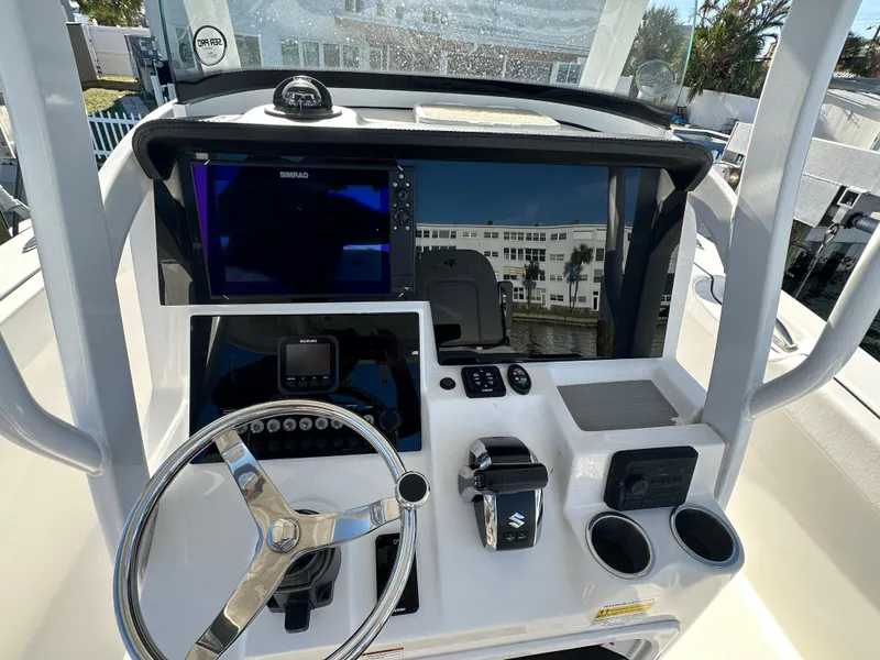 Slide: The Image of 2023 Sea Pro 239 Deep V CC boat dashboard with steering wheel and navigation controls. - 8