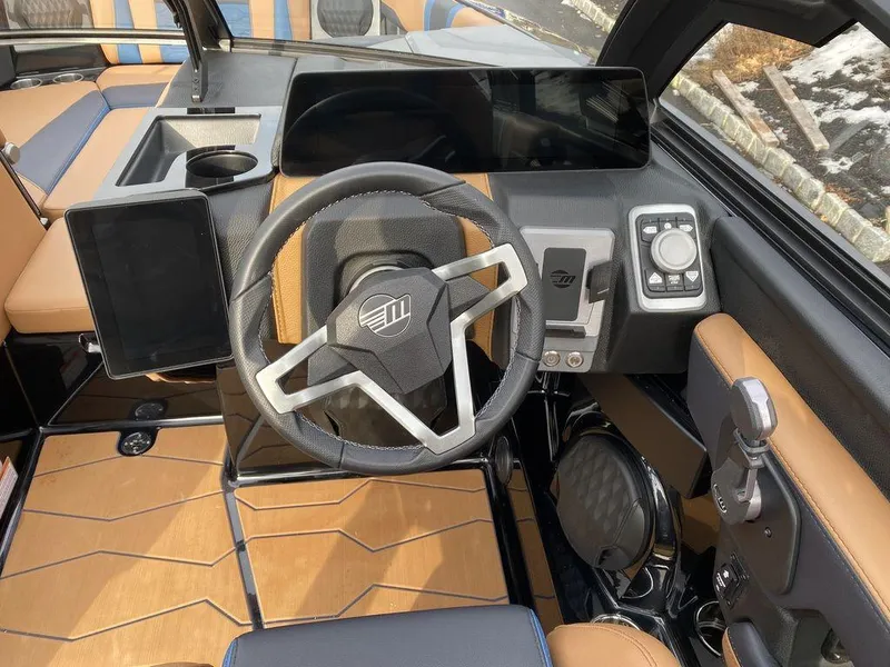 Slide: The Image of 2025 Malibu Wakesetter 22 MXZ interior with tan and blue seating, stylish design. - 14