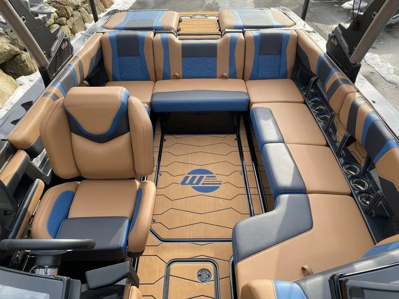 Slide: The Image of 2025 Malibu Wakesetter 22 MXZ interior with tan and blue seating, luxury design. - 16