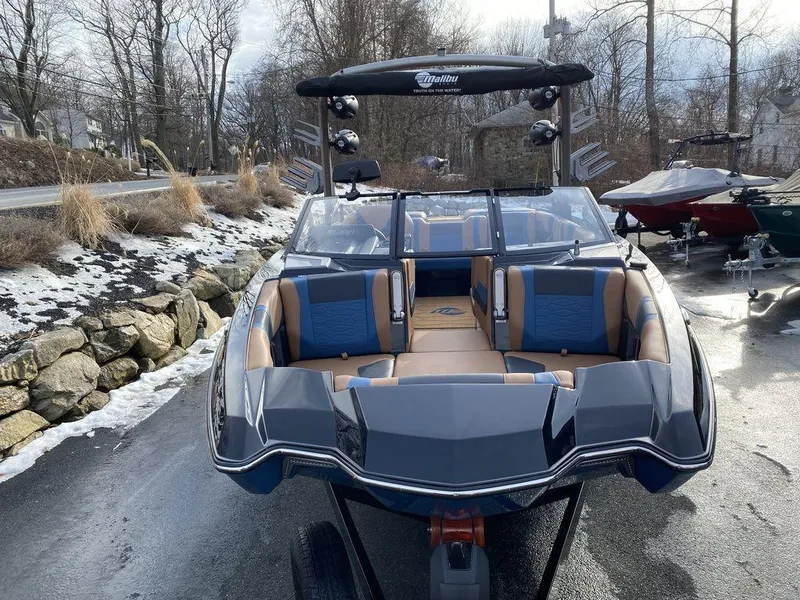 Slide: The Image of 2025 Malibu Wakesetter 22 MXZ boat on trailer outside dealership. - 8