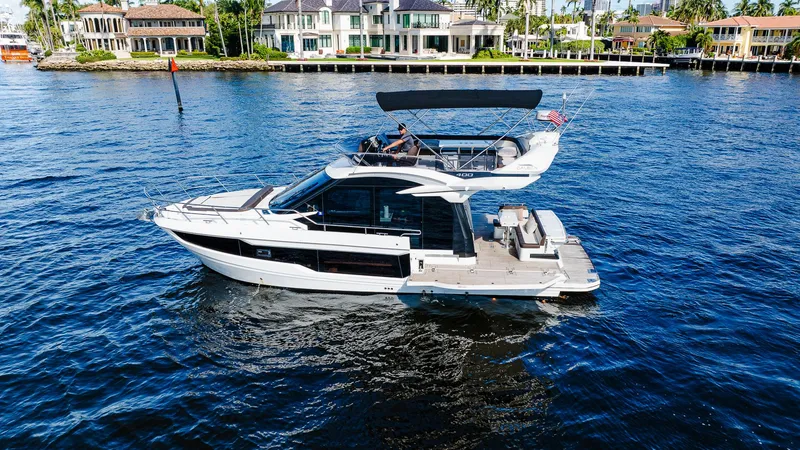 Slide: The Image of 2022 Galeon 400 Fly yacht cruising on a sunny waterfront. - 2