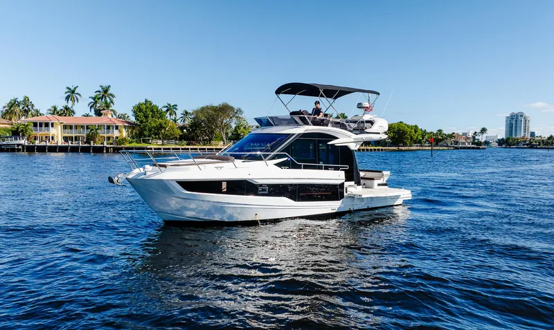 Slide: The Image of 2022 Galeon 400 Fly yacht cruising on a sunny day in a scenic waterway. - 6