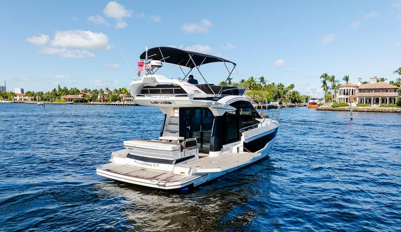 Slide: The Image of 2022 Galeon 400 Fly yacht cruising on a sunny day in a scenic waterway. - 8