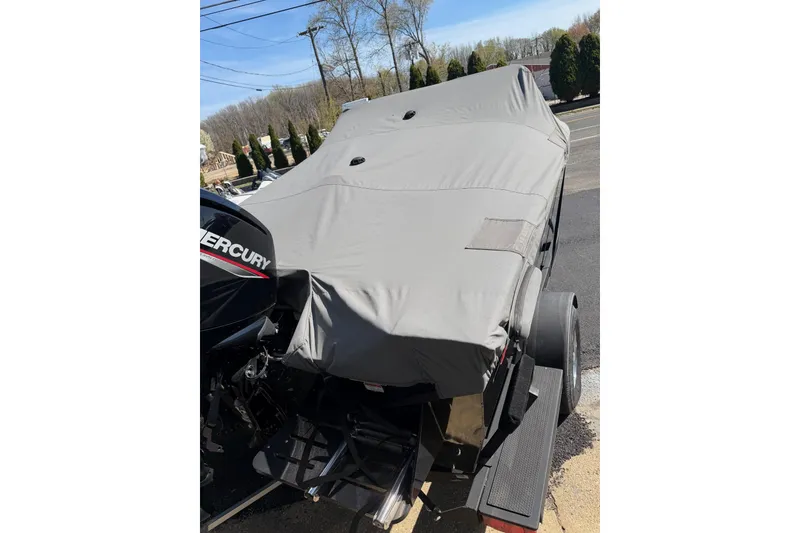 Slide: The Image of 2022 Tracker Pro Guide V-175 WT boat covered, parked on a trailer outdoors. - 16