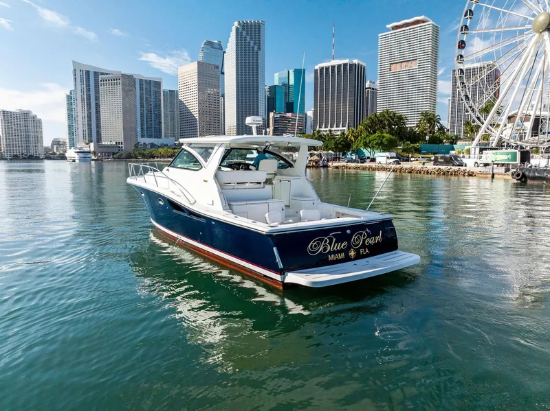 Slide: The Image of 2004 Tiara Yachts 4200 Open in city harbor with skyline and Ferris wheel. - 1