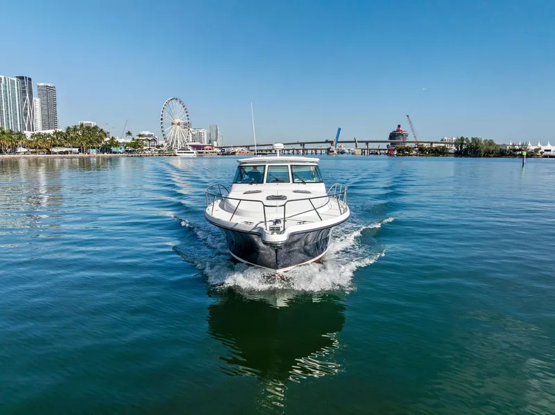 Slide: The Image of 2004 Tiara Yachts 4200 Open cruising in a scenic waterfront setting. - 16