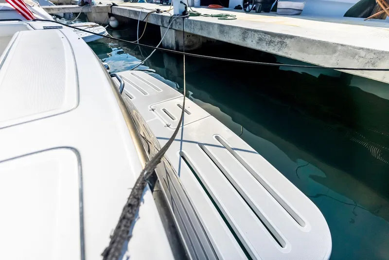 Slide: The Image of 2004 Tiara Yachts 4200 Open docked, showing swim platform and mooring lines. - 27