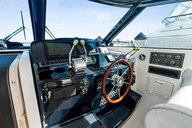 Slide: The Image of 2004 Tiara Yachts 4200 Open helm with steering wheel and control panel. - 30