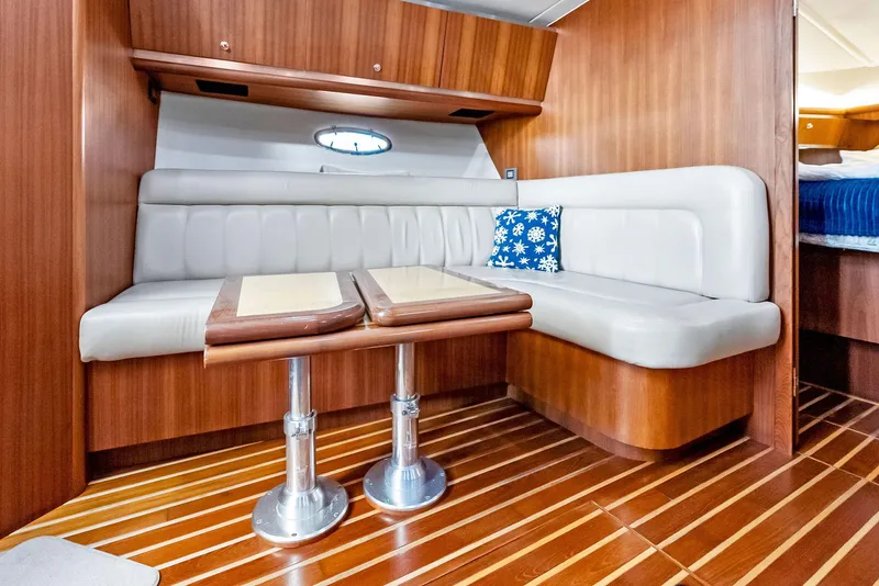 Slide: The Image of 2004 Tiara Yachts 4200 Open interior with wood finish and cushioned seating. - 38