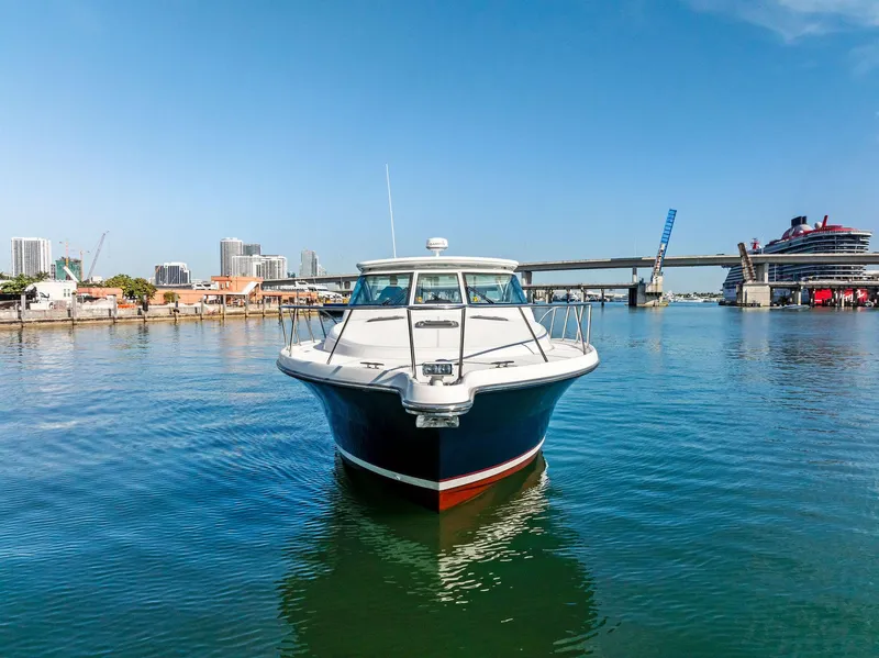 Slide: The Image of 2004 Tiara Yachts 4200 Open in marina, cityscape and bridge in background. - 4