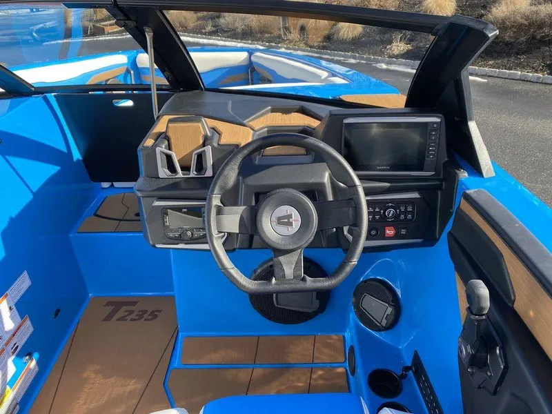 Slide: The Image of 2025 Axis T235 boat cockpit with steering wheel, control panel, and blue interior. - 10