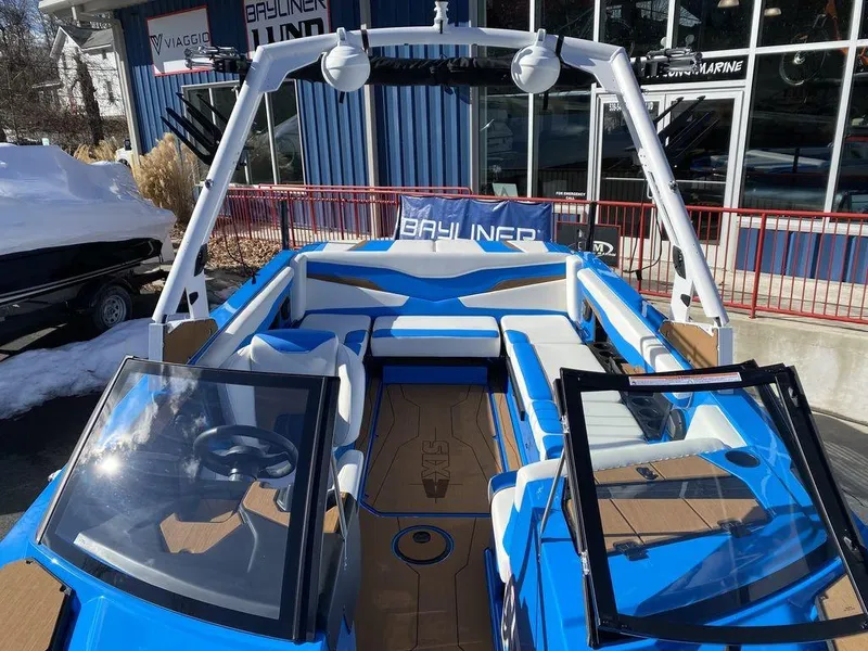 Slide: The Image of 2025 Axis T235 boat with blue and white interior, displayed at a marina. - 13