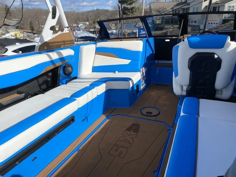 Slide: The Image of Interior of 2025 Axis T235 boat with blue and white seating, docked outdoors. - 15