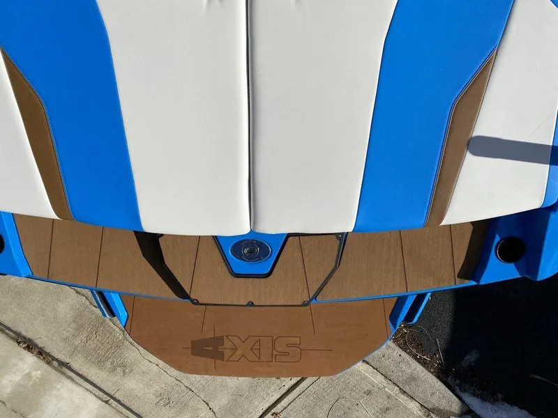 Slide: The Image of 2025 Axis T235 boat with blue and white upholstery, brown deck, and logo detail. - 18