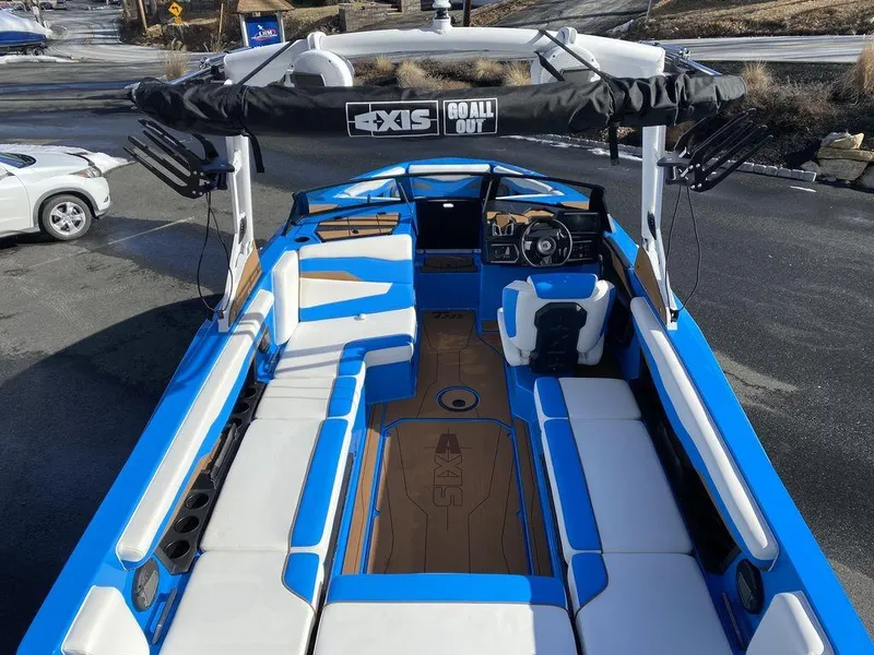 Slide: The Image of 2025 Axis T235 boat with blue and white interior, spacious seating, and advanced steering console. - 7