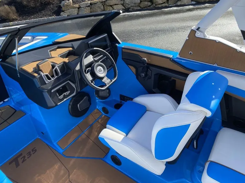 Slide: The Image of 2025 Axis T235 boat interior with blue and white seating, modern dashboard, and steering wheel. - 8