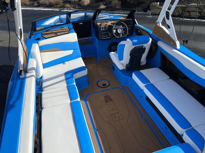 Slide: The Image of 2025 Axis T235 boat interior with blue and white seating, modern dashboard, and spacious layout. - 9