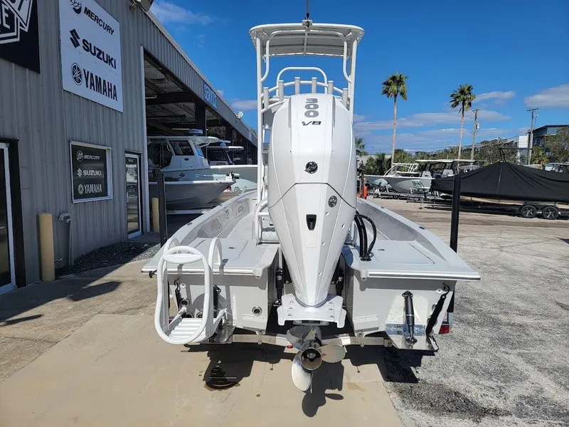Slide: The Image of 2025 Shallow Sport 24 Modified V boat with outboard motor at a dealership. - 13