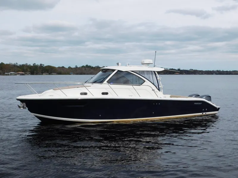 Slide: The Image of 2018 Pursuit OS 325 Offshore boat on calm water under cloudy sky. - 1