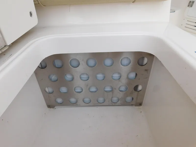 Slide: The Image of 2018 Pursuit OS 325 Offshore boat storage compartment with perforated metal panel. - 20