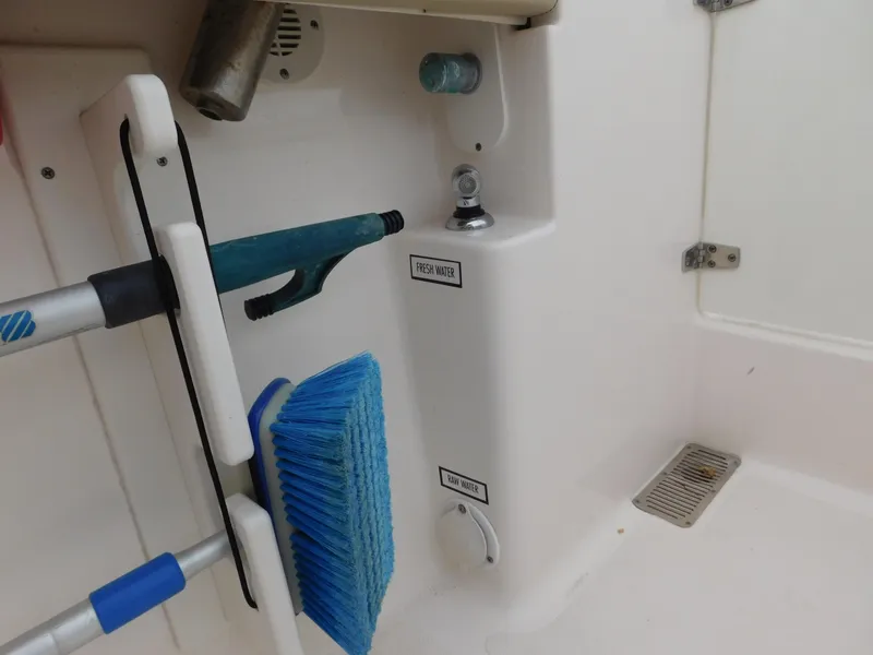 Slide: The Image of 2018 Pursuit OS 325 Offshore boat cleaning tools and storage area. - 32