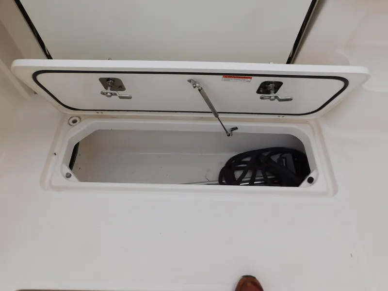 Slide: The Image of Storage compartment on 2018 Pursuit OS 325 Offshore boat, open with visible contents. - 42