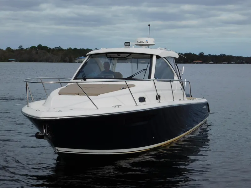 Slide: The Image of 2018 Pursuit OS 325 Offshore boat on calm water under cloudy sky. - 6